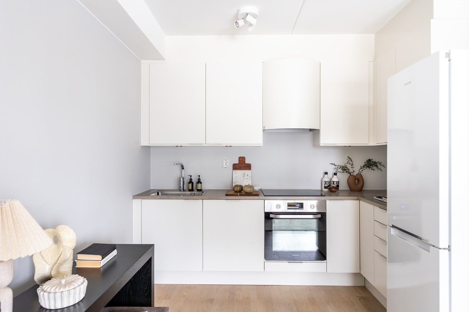 Kjøkkenet har glatte fronter, laminat benkeplate med nedfelt vaskekum, samt belysning over benkeplaten. Galleribilde