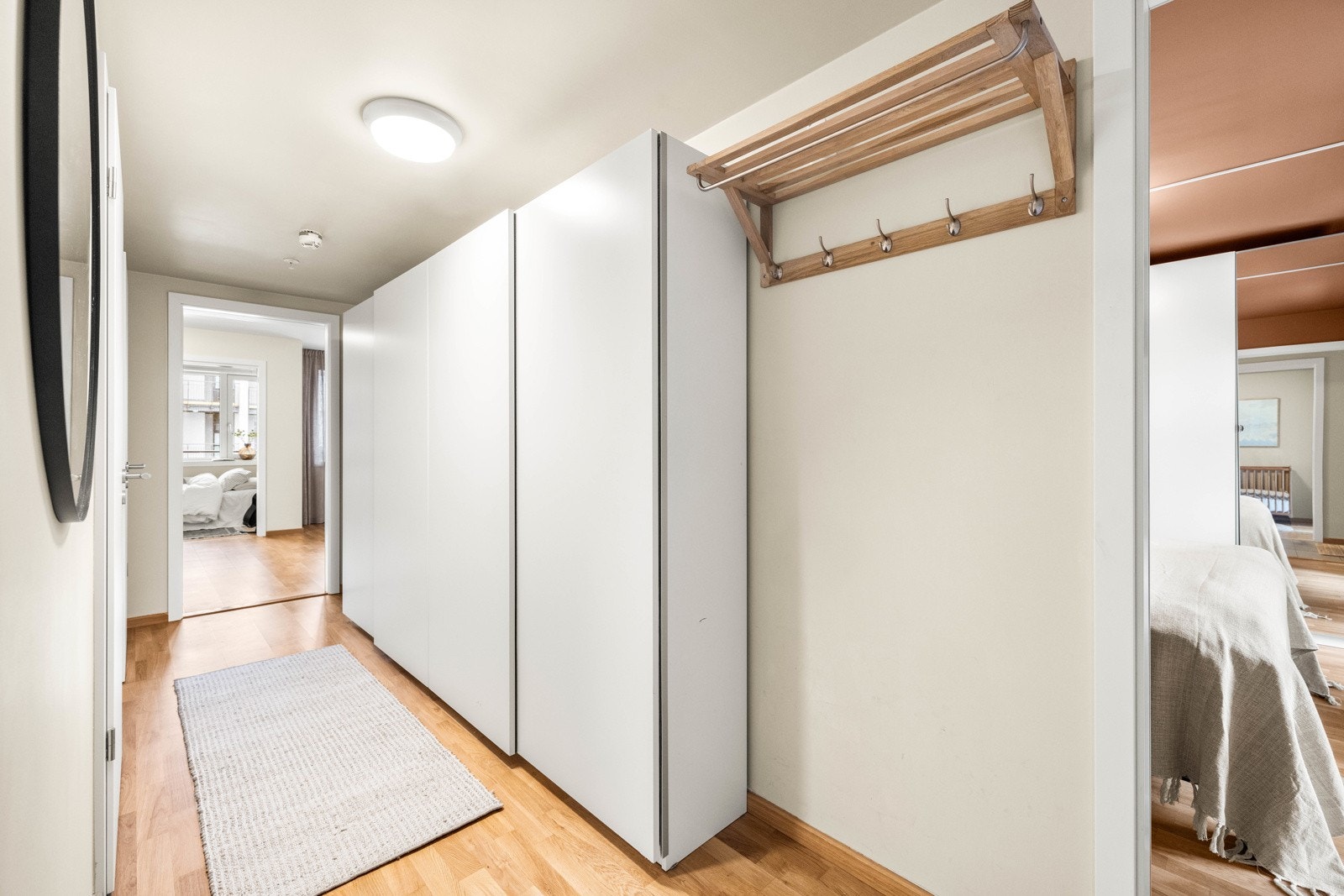 Langstrakt entré med skyvedørsgarderobe og delvis flislagt gulv. Det er vannbåren varme i alle gulv. Galleribilde