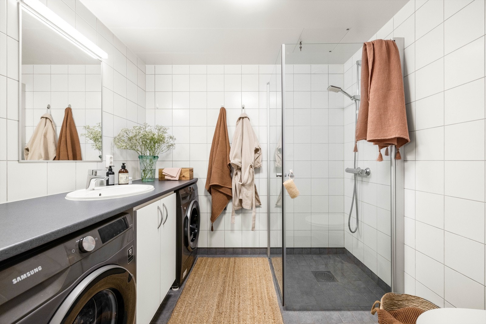 Romslig og flislagt bad med gulvvarme, mekanisk avtrekk og opplegg for vaskemaskin og tørketrommel. Galleribilde