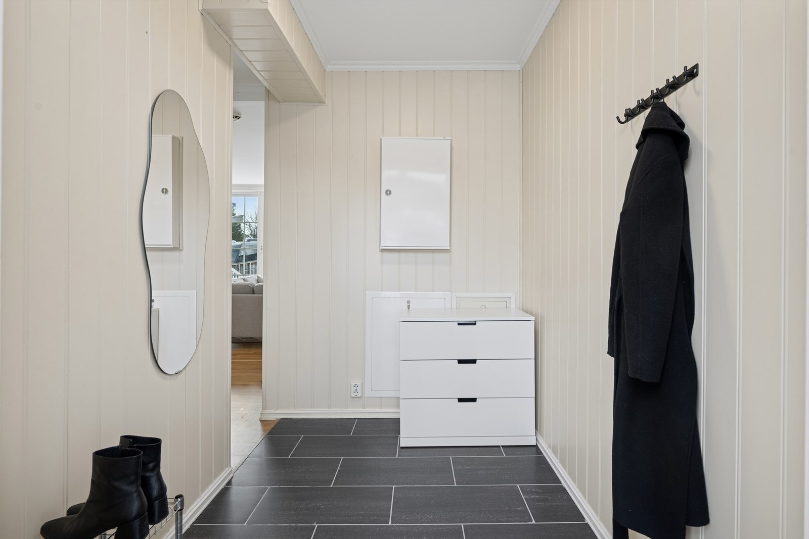 Entréen har flislagt gulv med vannbåren gulvvarme, som gir en behagelig og praktisk velkomst. Her er det god plass til å henge fra seg yttertøy og sette fra seg fottøy. Galleribilde