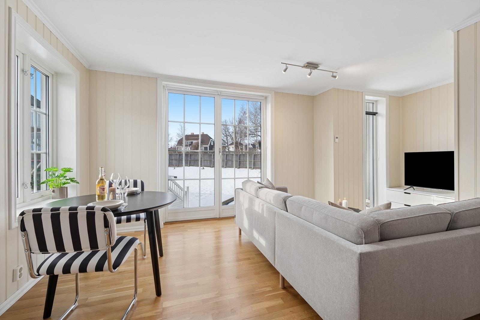 Store vindusflater slipper inn rikelig med dagslys og gir rommet en lys og luftig atmosfære. Galleribilde