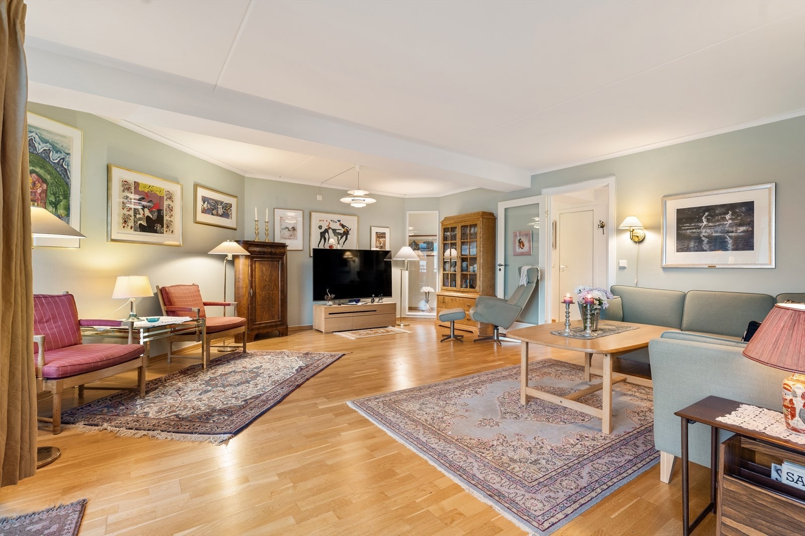 Leilighetens oppholdsrom er luftig og lyst med naturlig lys fra store vindusflater. Galleribilde