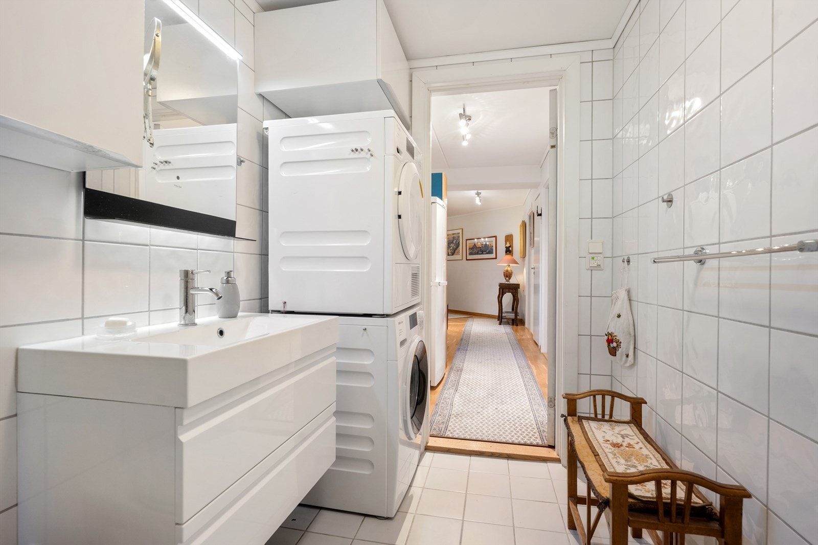 Rommet er innredet med nedfelt servant, dusj på gulv, speil over servant og opplegg for vaskemaskin. Galleribilde