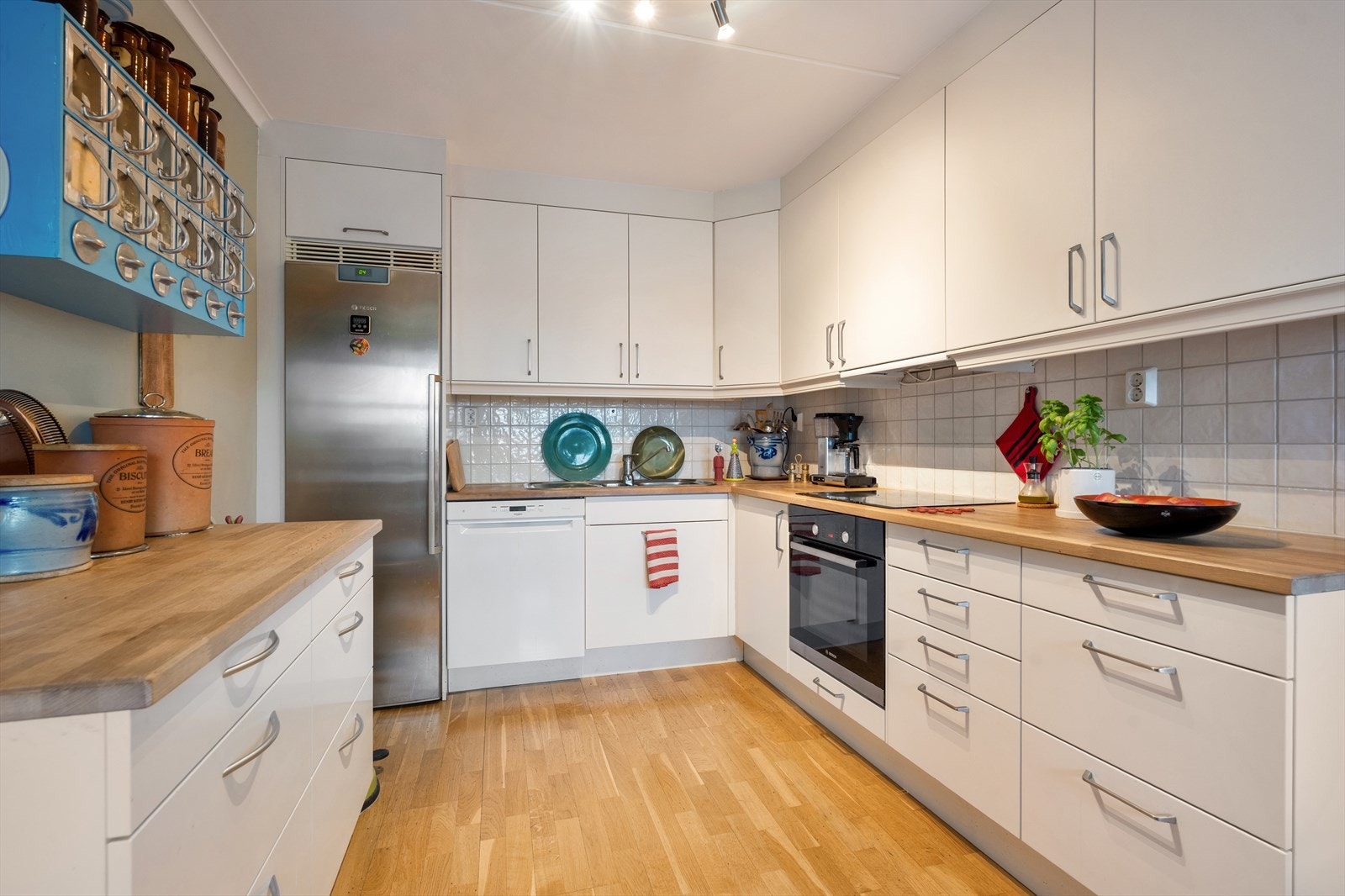 Kjøkkenet er stort med mye skap- og benkeplass. Innredningen består av glatte fronter og heltre benkeplate med nedfelt kum i rustfritt stål. Galleribilde