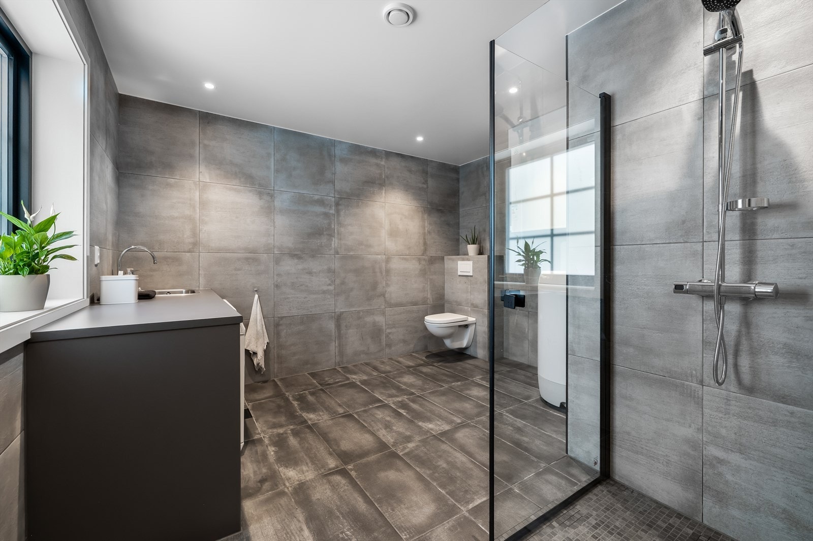 Det er kombinert vaskerom/ baderom i første etasje. Helfliset med delikate fliser og det er varmekabler i gulvet. Galleribilde