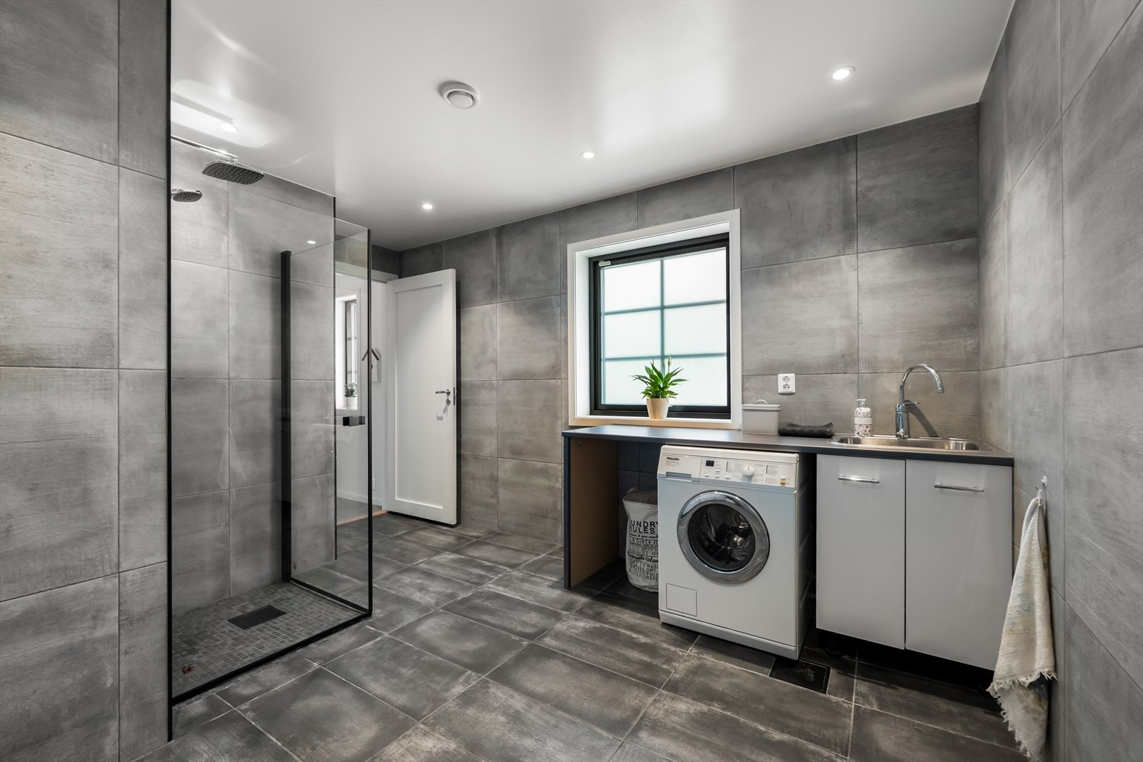 Integrert benkeplate med nedfelt stål utslagskum og opplegg for vaskemaskin gir praktiske løsninger. Galleribilde