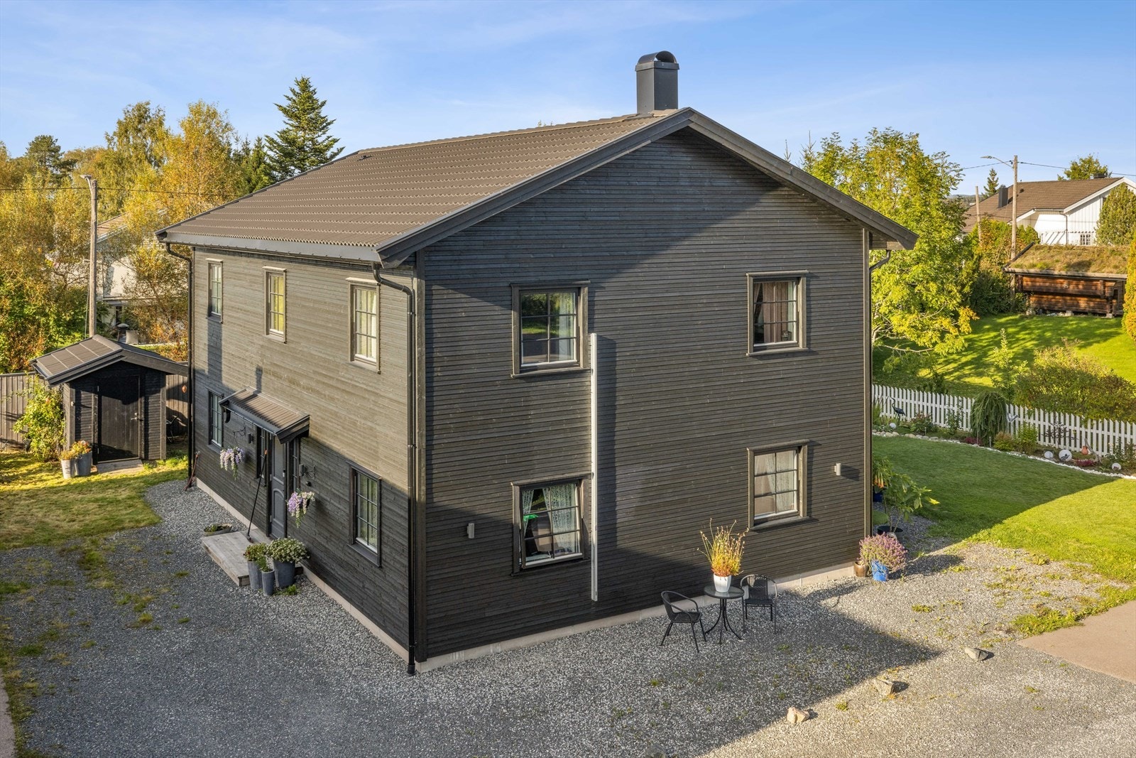 Eiendommen har en flat tomt med plen og gruset gårdsplass for parkering. Galleribilde