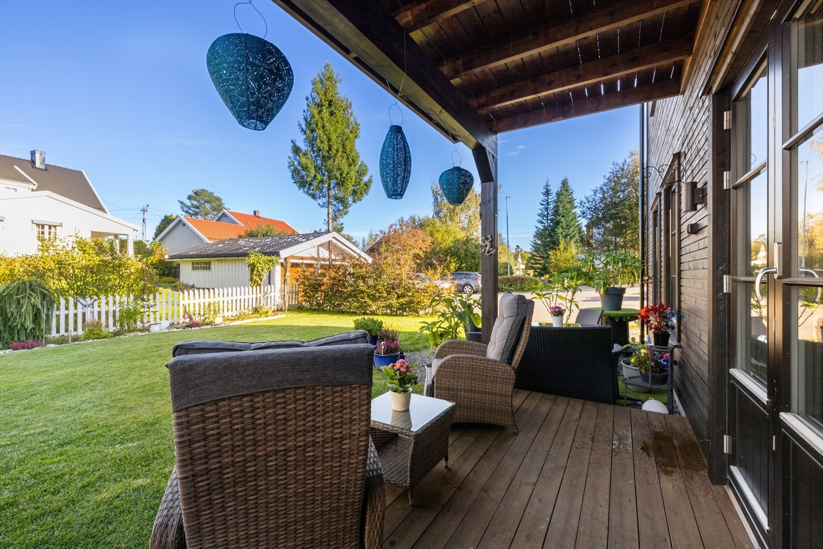 Terrasse med videre adkomst til plen og frodig hage. Galleribilde