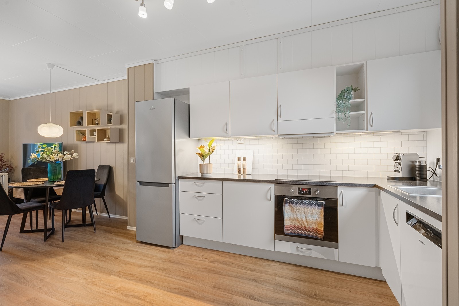 Flott kjøkkeninnredning med integrert koketopp og stekeovn. Frittstående oppvaskmaskin og kjøleskap. Galleribilde