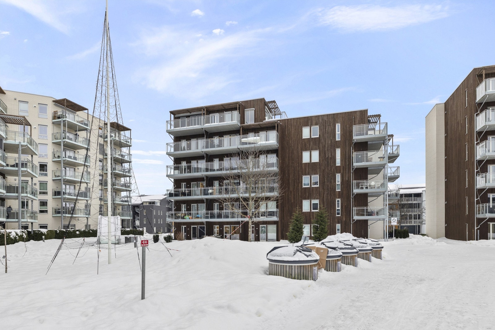 Bygget har en moderne fasade med en kombinasjon av teglstein og trepanel. Galleribilde