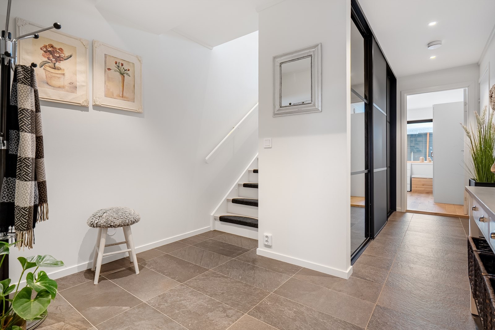 Rommet gir et ryddig og innbydende førsteinntrykk, med trapp som leder til boligens øvrige etasjer Galleribilde