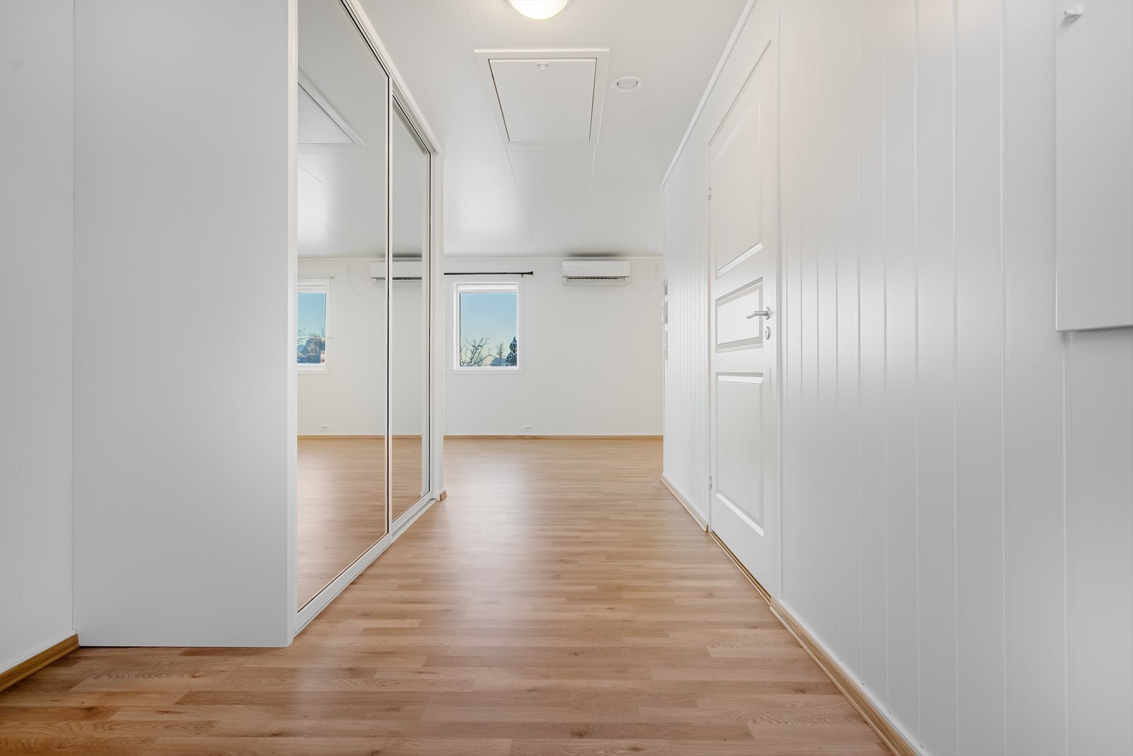 Romslig og praktisk entré med god plass til oppheng av yttertøy og oppbevaring av sko i skyvedørsgarderobe - Entréen gir et godt førsteinntrykk og en funksjonell adkomst til boligen Galleribilde