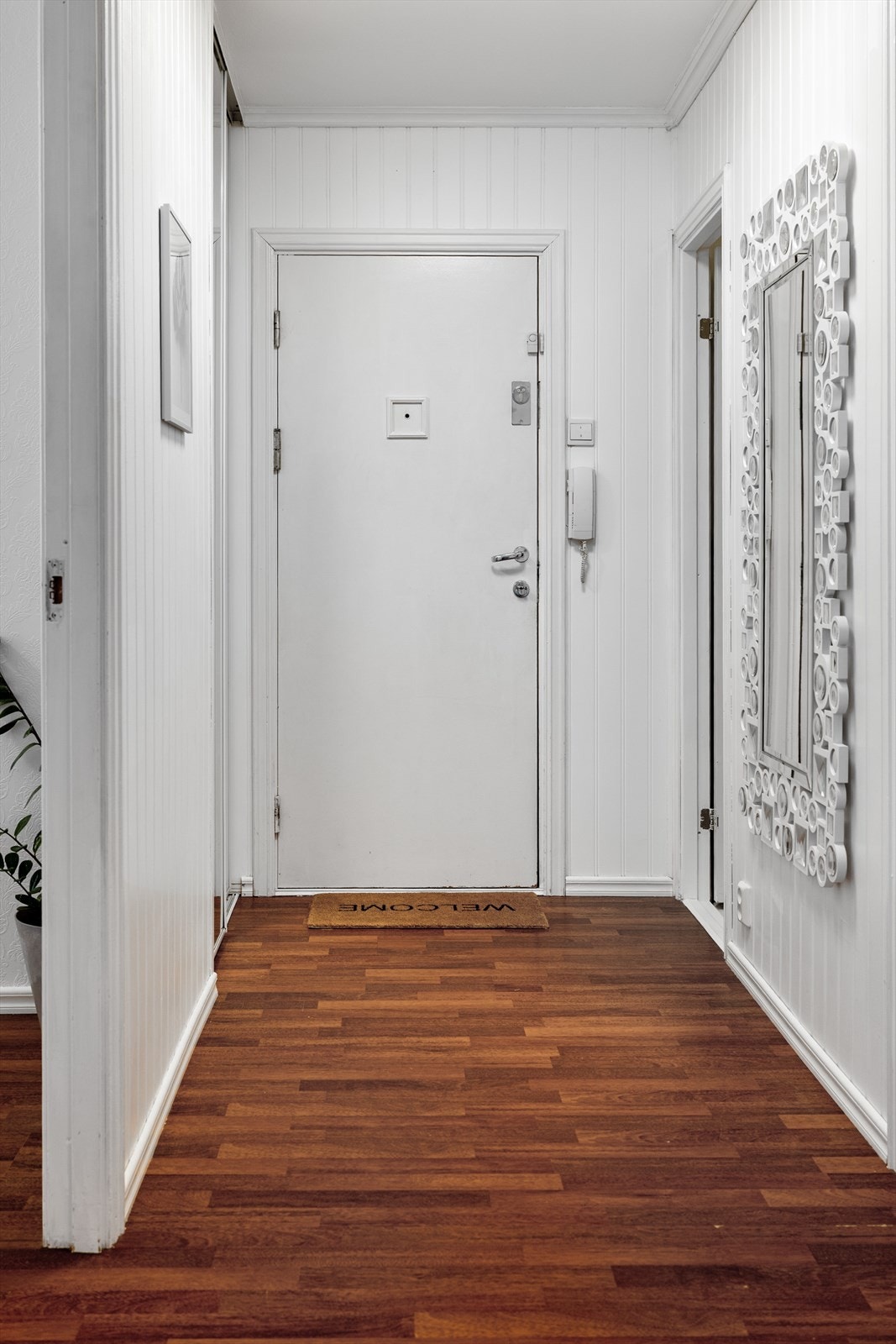 Entreen gir et godt førsteinntrykk av leiligheten. Her har du en praktisk skyvedørsgarderobe med speilfront. Galleribilde