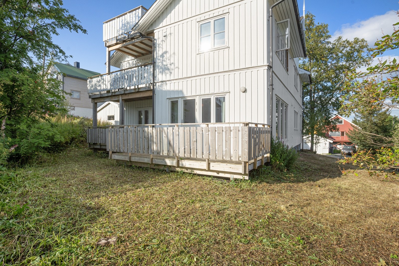 Eiendommen er omkranset av plen og prydbusker.