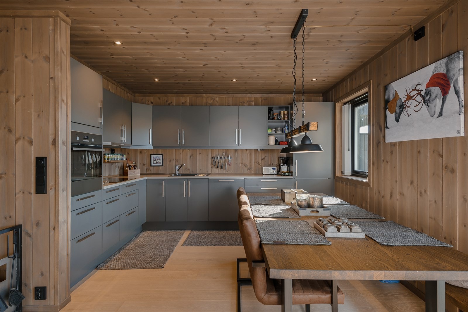 Romslig kjøkken i L-form med integrerte hvitevarer. Rikelig med skap-og benkeplass. Galleribilde