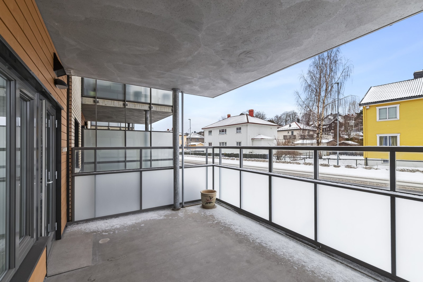 Verandaen ligger over bakkeplan med høye glassvegger, skjermet for innsyn Galleribilde