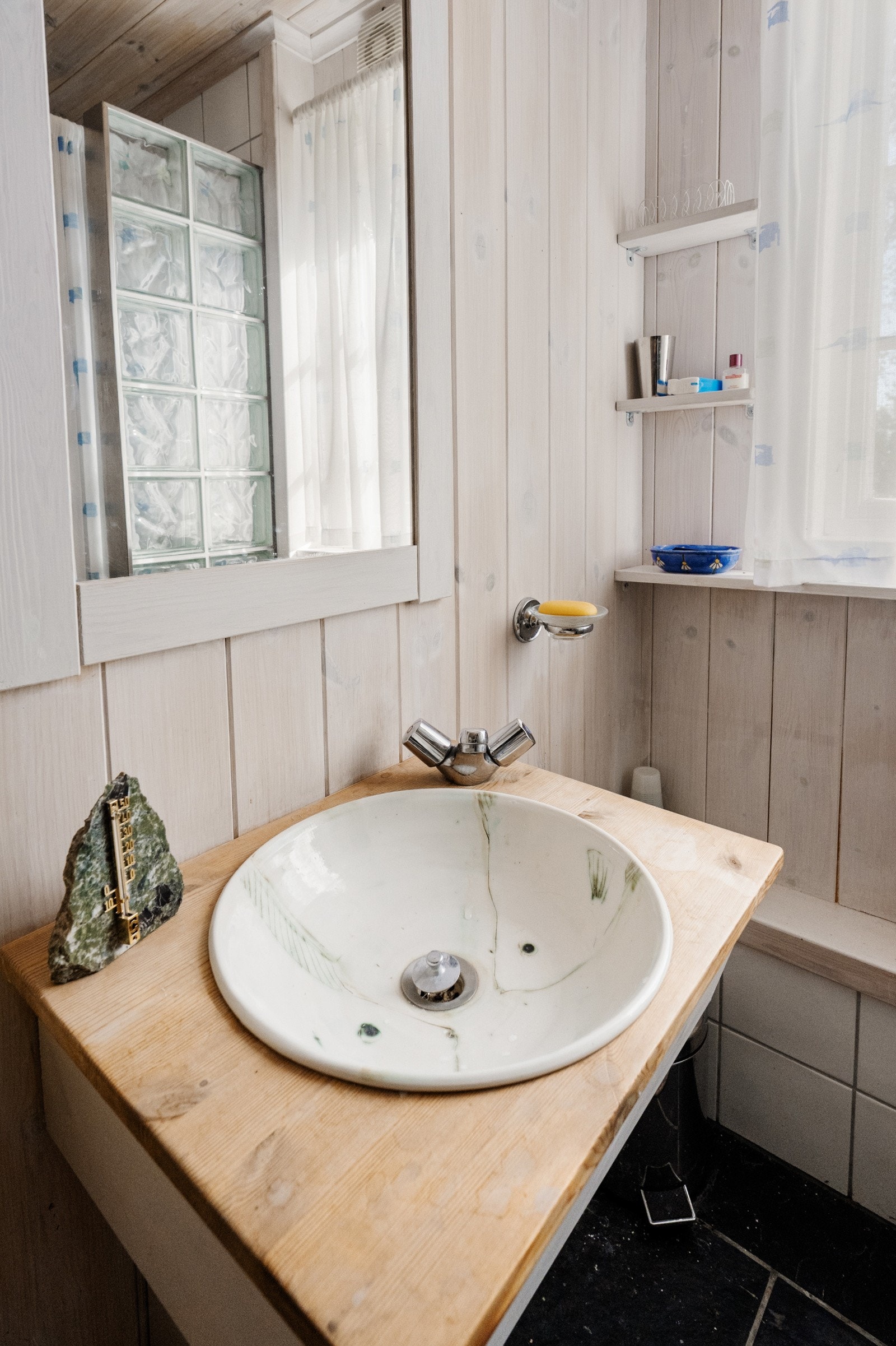 Pent bad med flislagt gulv og gulvvarme for ekstra komfort. Det er montert en liten varmtvannsbereder på vegg. Galleribilde