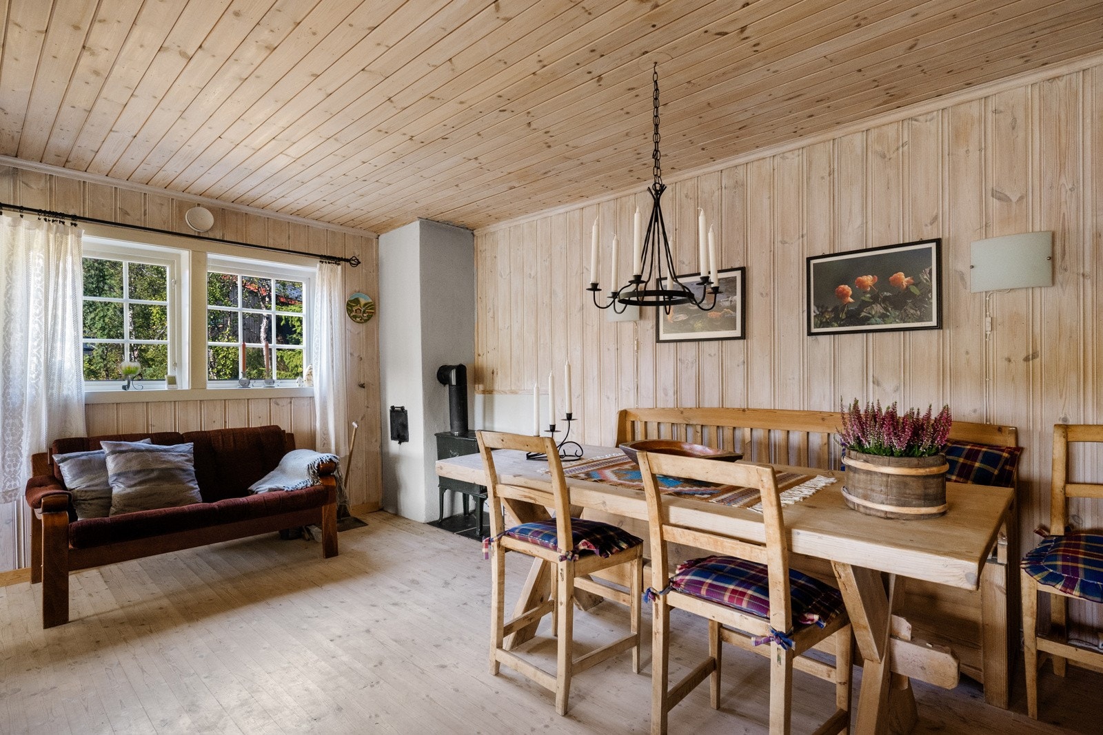 Rommet er preget av tradisjonelle hytteinteriør med heltre gulv og trepanel på både vegger og himling, noe som skaper en varm og innbydende atmosfære. Galleribilde