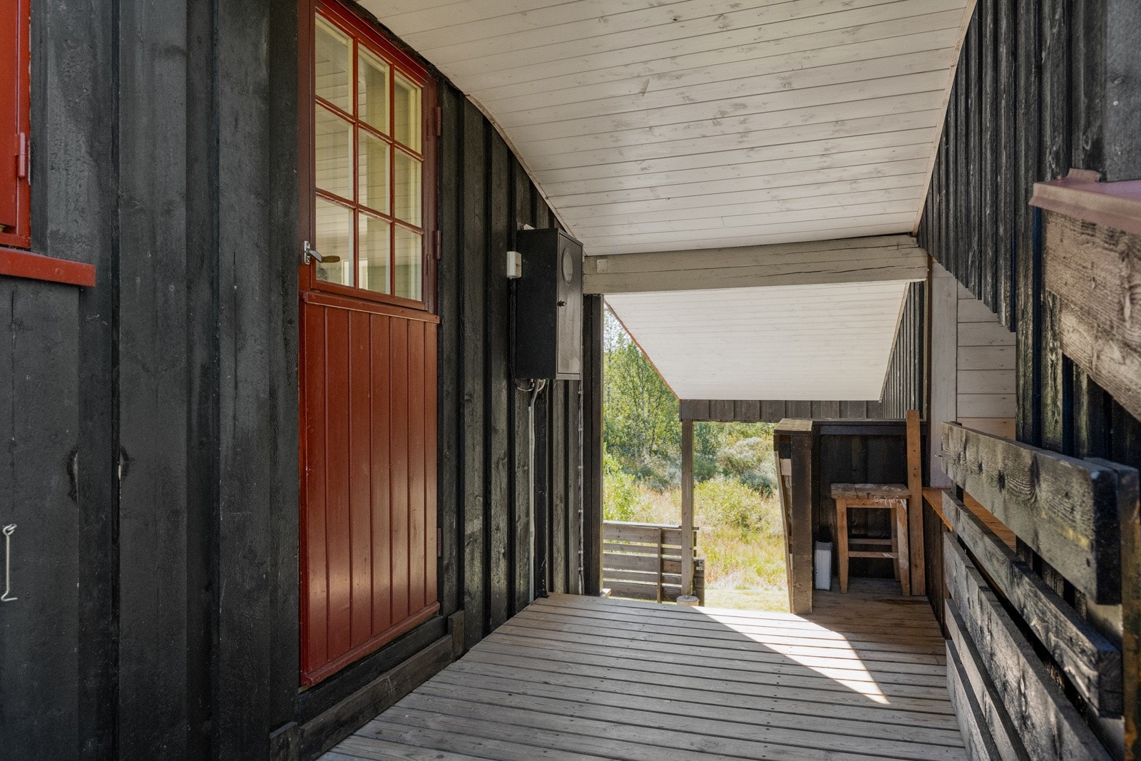 Mellom hovedhytten og annekset er det et praktisk overbygg som gir le for vær og vind, og skaper en lun og funksjonell overgang mellom byggene. Galleribilde