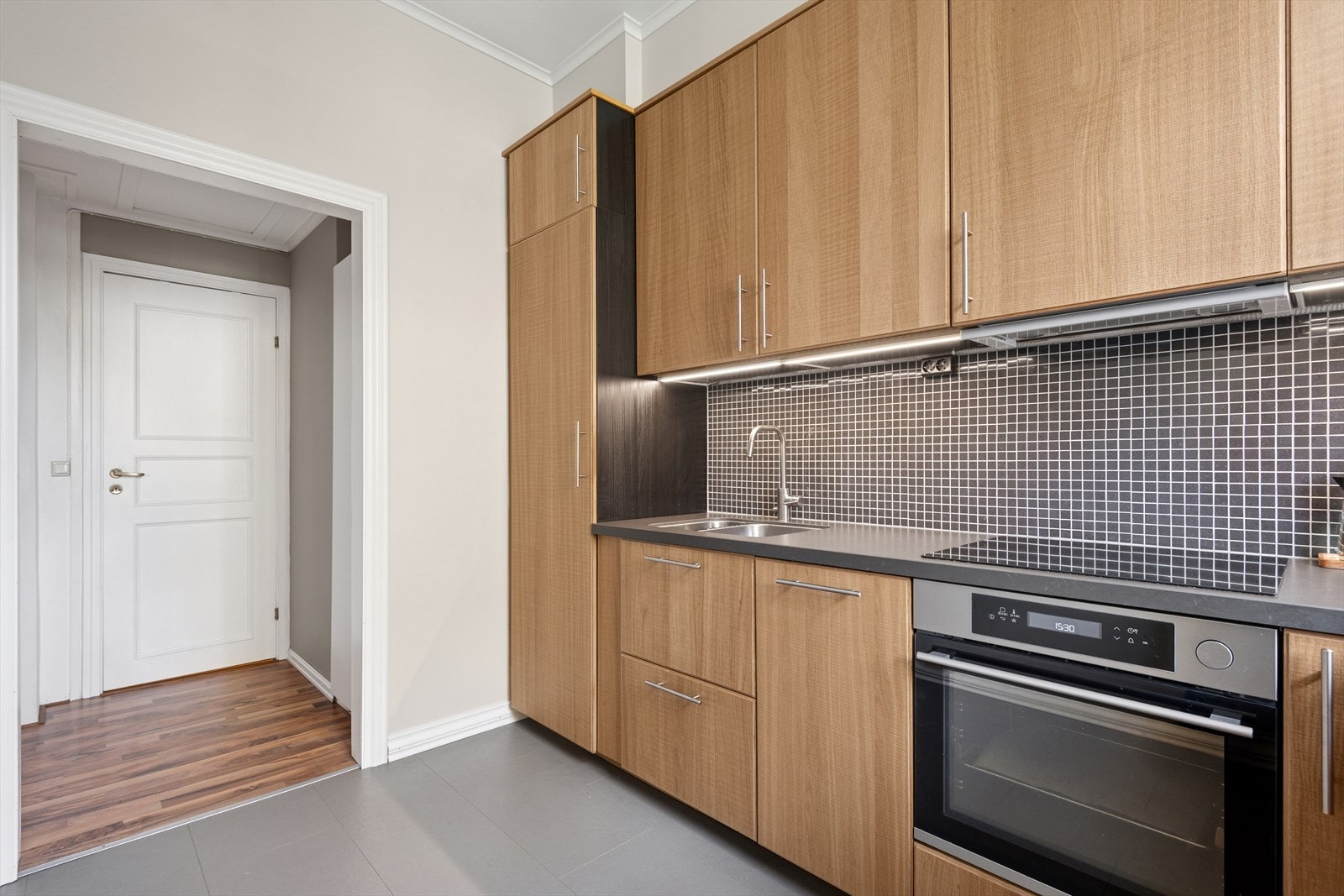 Boligens kjøkken er utstyrt med en nyere Ikea kjøkkeninnredning med slette fronter, laminerte og finerte skrog, samt laminerte benkeplater. Galleribilde