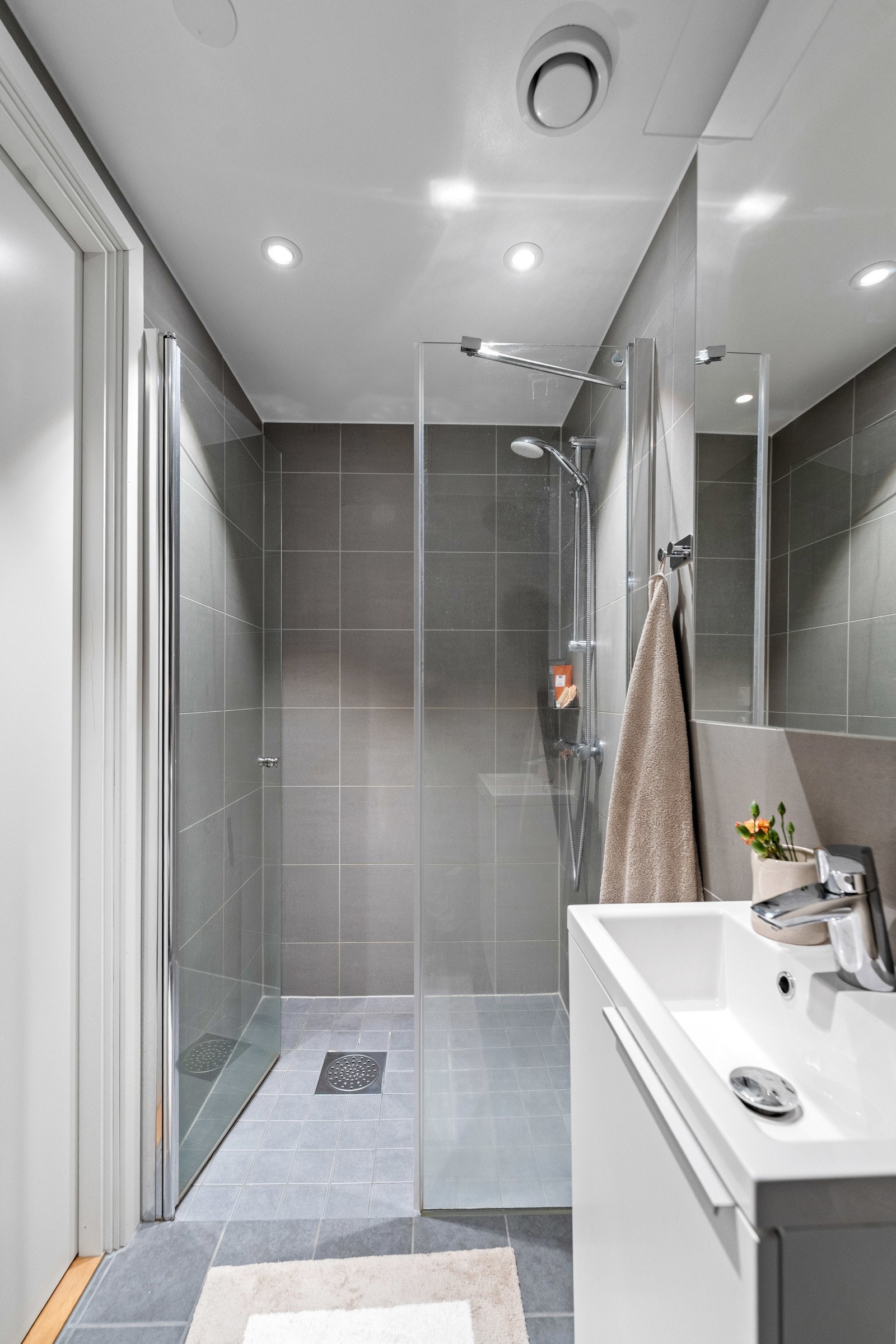 Dusjhjørne med innfellbare dører, servant med underskap og vegghengt wc Galleribilde