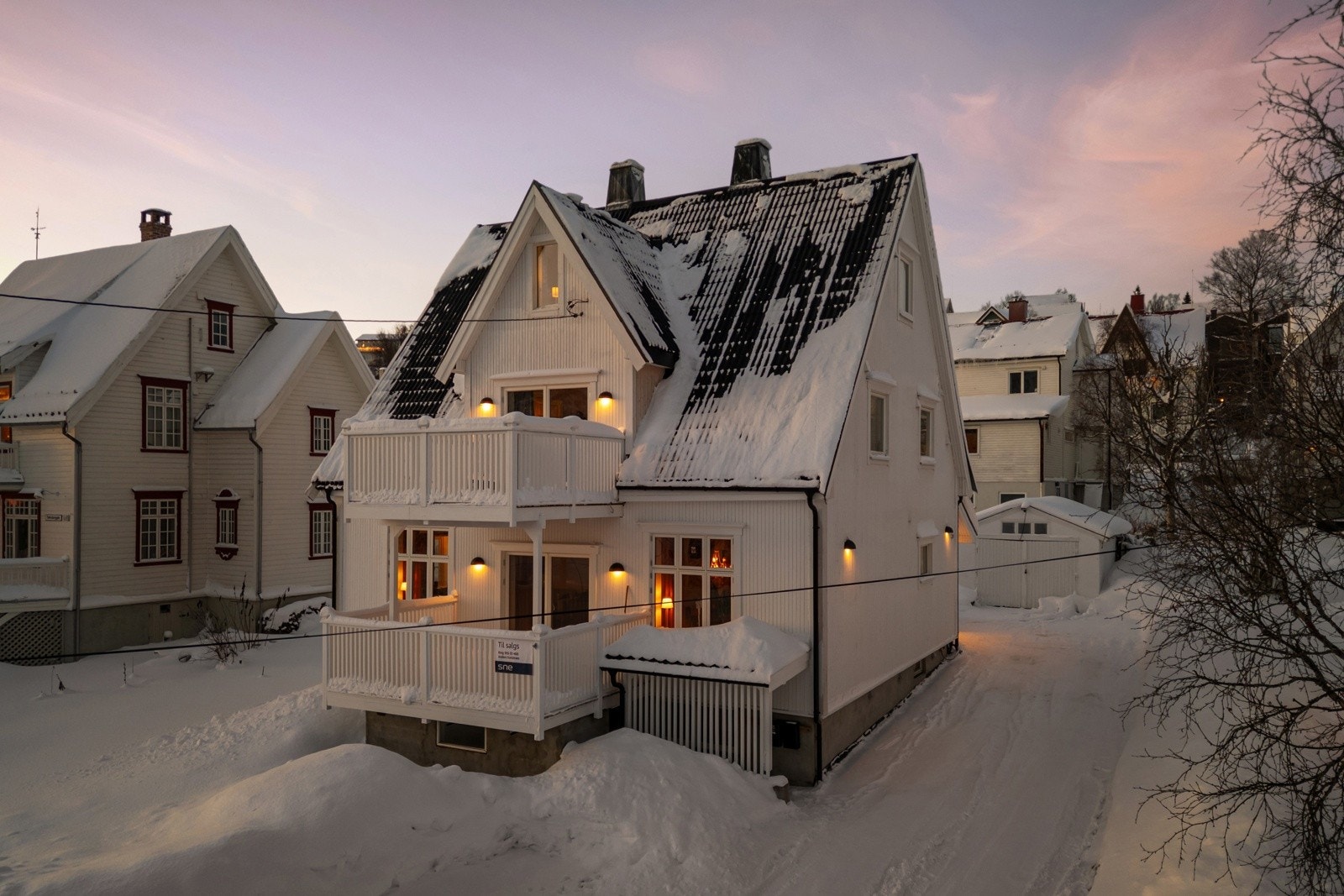 Eiendomstomt med stor hage med plen, enkel garasje og rikelig med oppstillingsplasser for bil i innkjørselen.