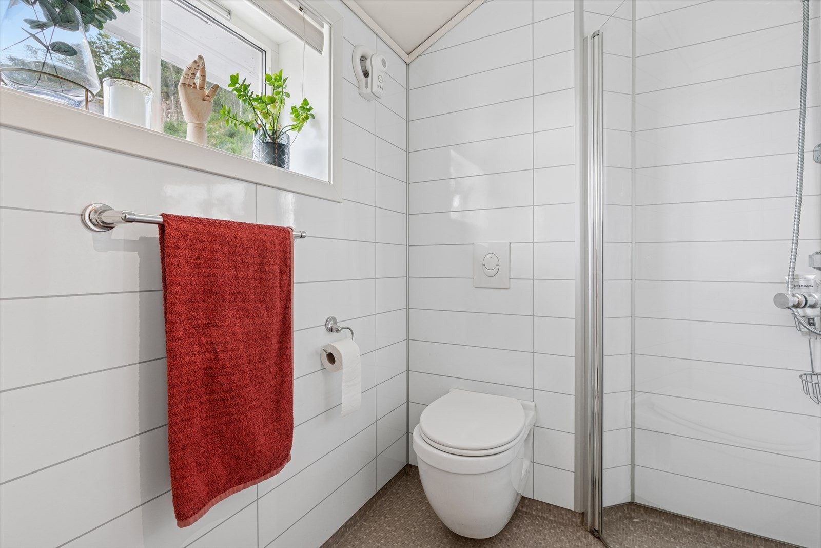 Badet har baderomsplater på veggene og vinylbelegg på gulvet med elektriske varmekabler. Galleribilde