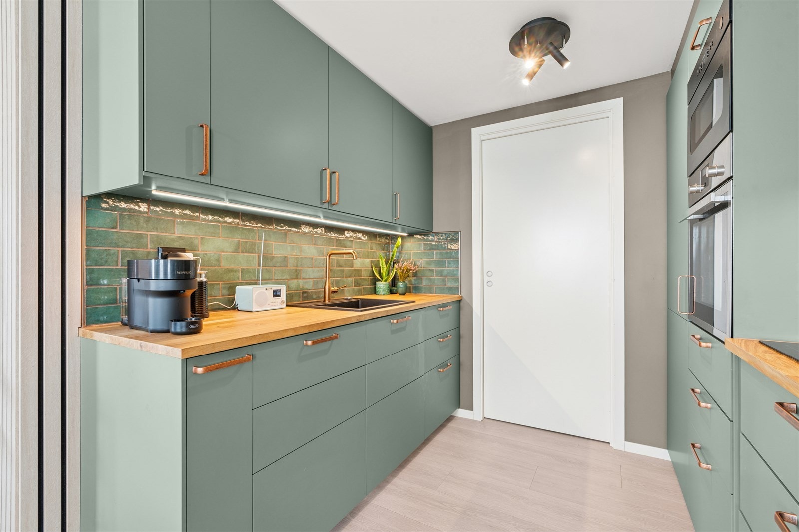 Kjøkkenet har innredning med glatte fronter og heltre benkeplate. Galleribilde