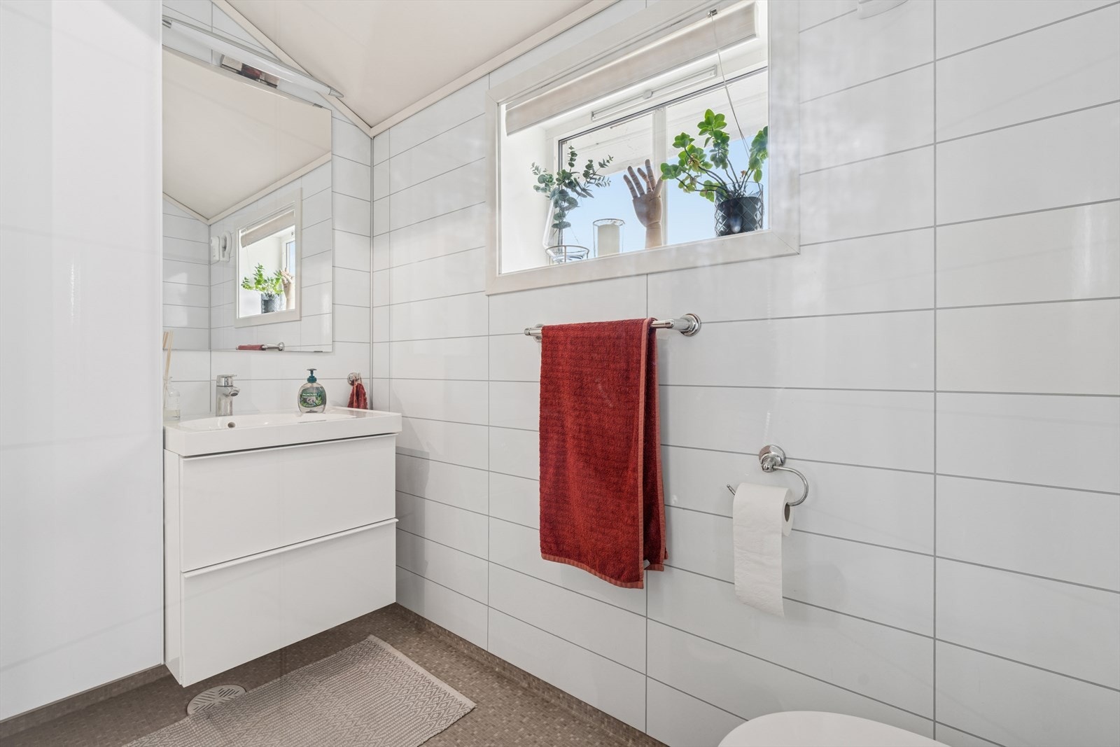 Badet i andre etasje er utstyrt med innredning med nedfelt servant, veggmontert toalett og dusjhjørne. Galleribilde