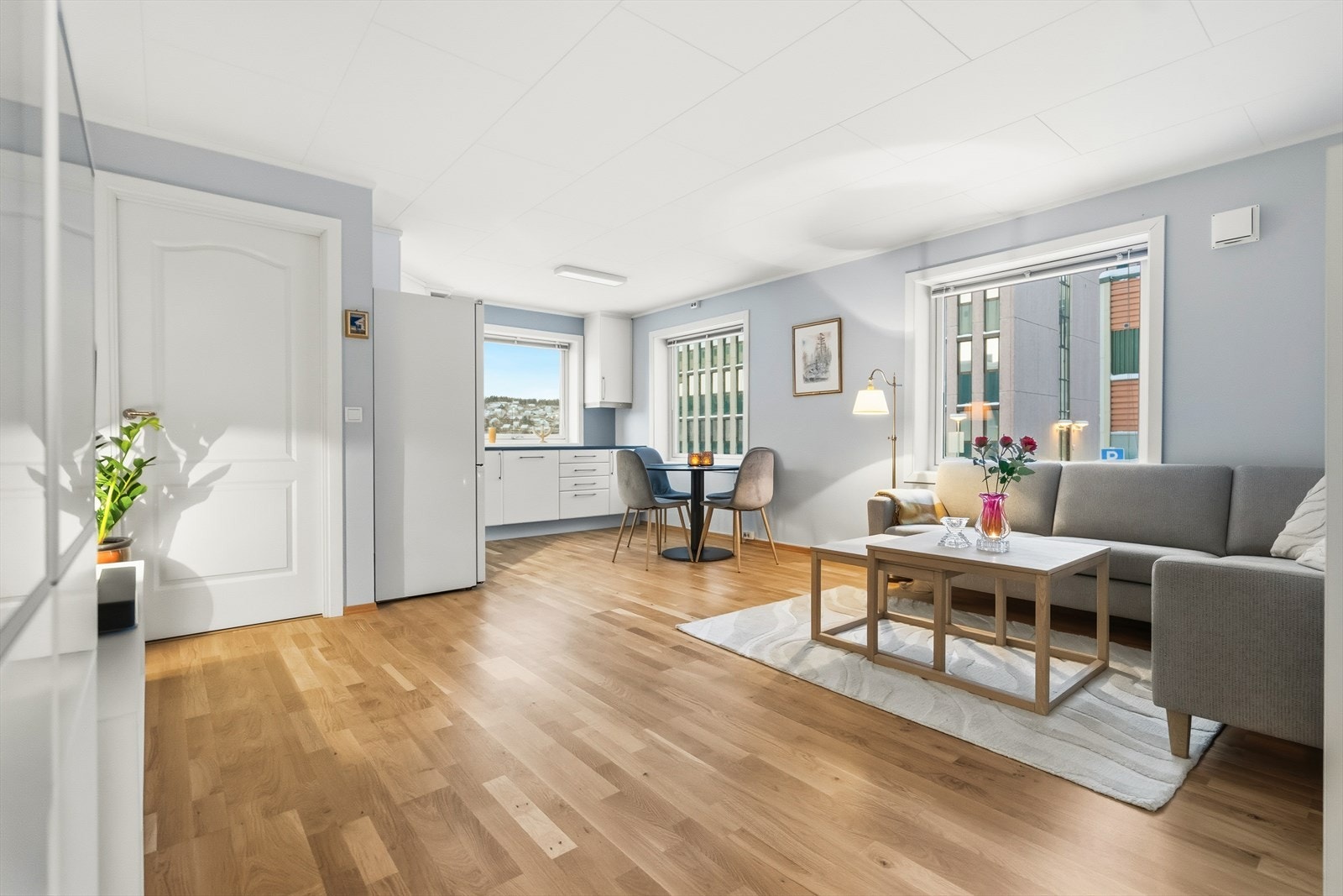 Velkommen til Dronningens gate 11 - Lys og innbydende stue med åpen løsning inn til kjøkken. Foto: Hanna Kristensen Galleribilde