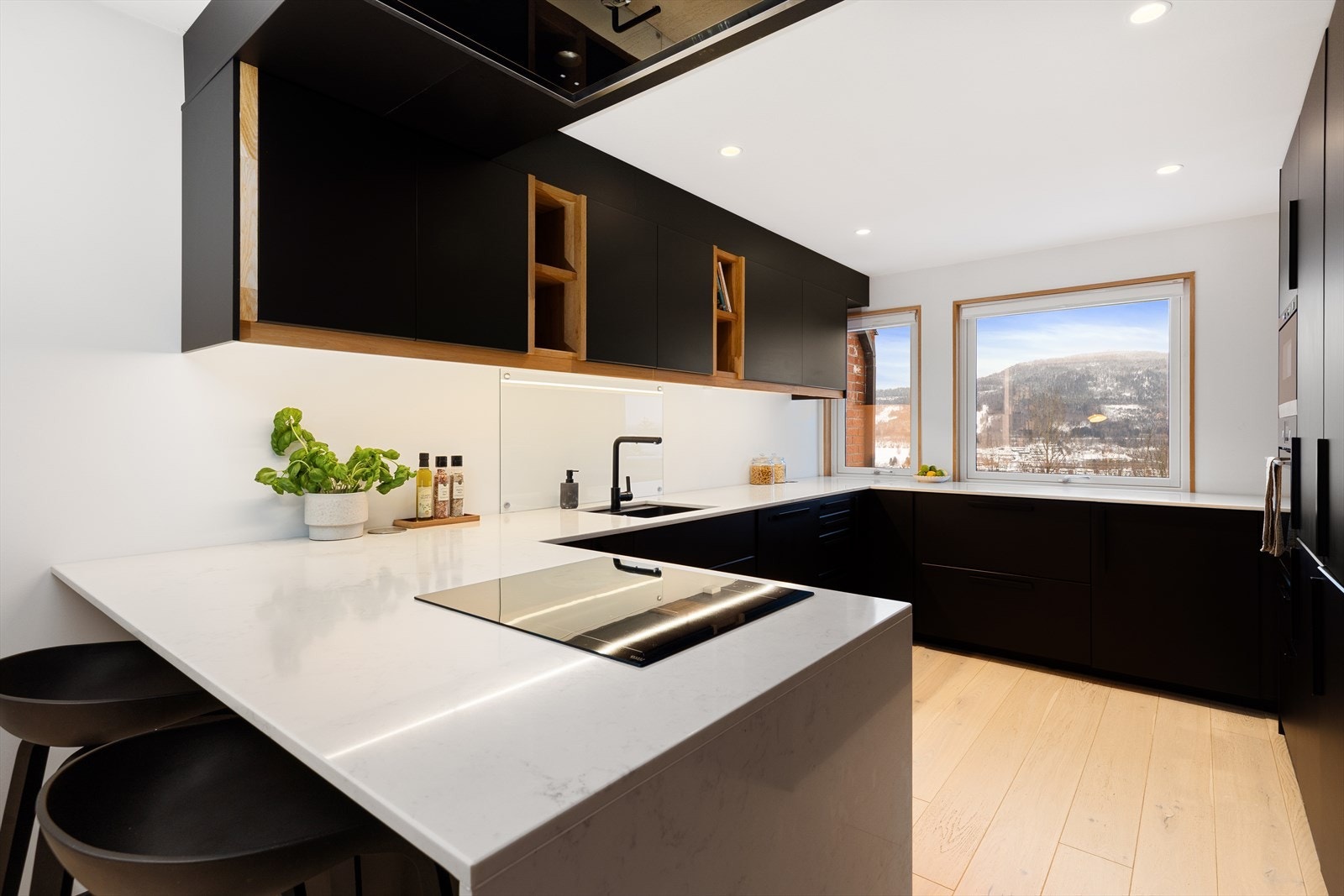 Stilrent og moderne IKEA-kjøkken med sorte slette fronter og lys benkeplate i solid stein utførelse. Galleribilde