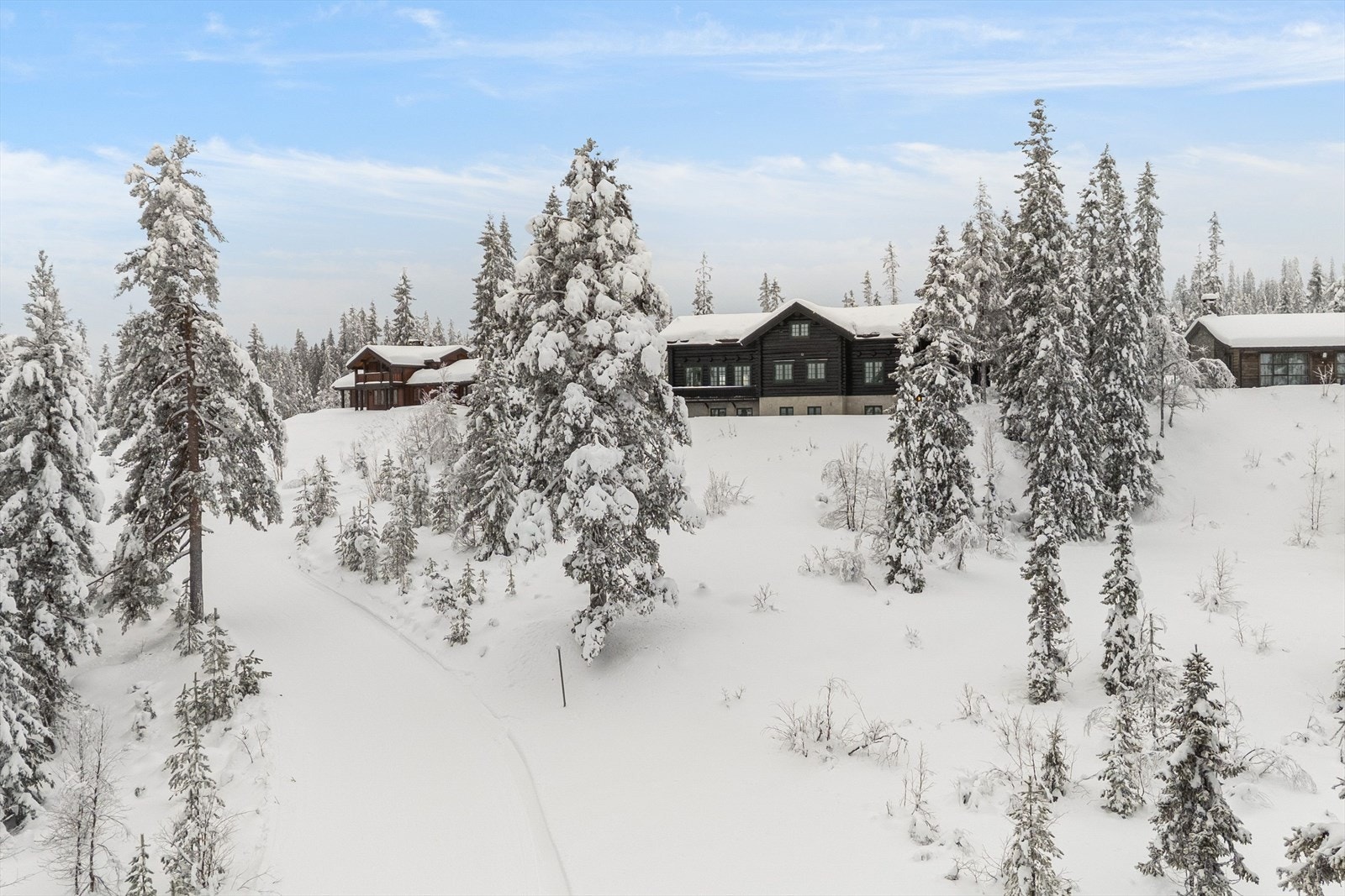Hytta sett fra ski-inn løype, og langrennsløype tilknyttet løypenettet. Galleribilde
