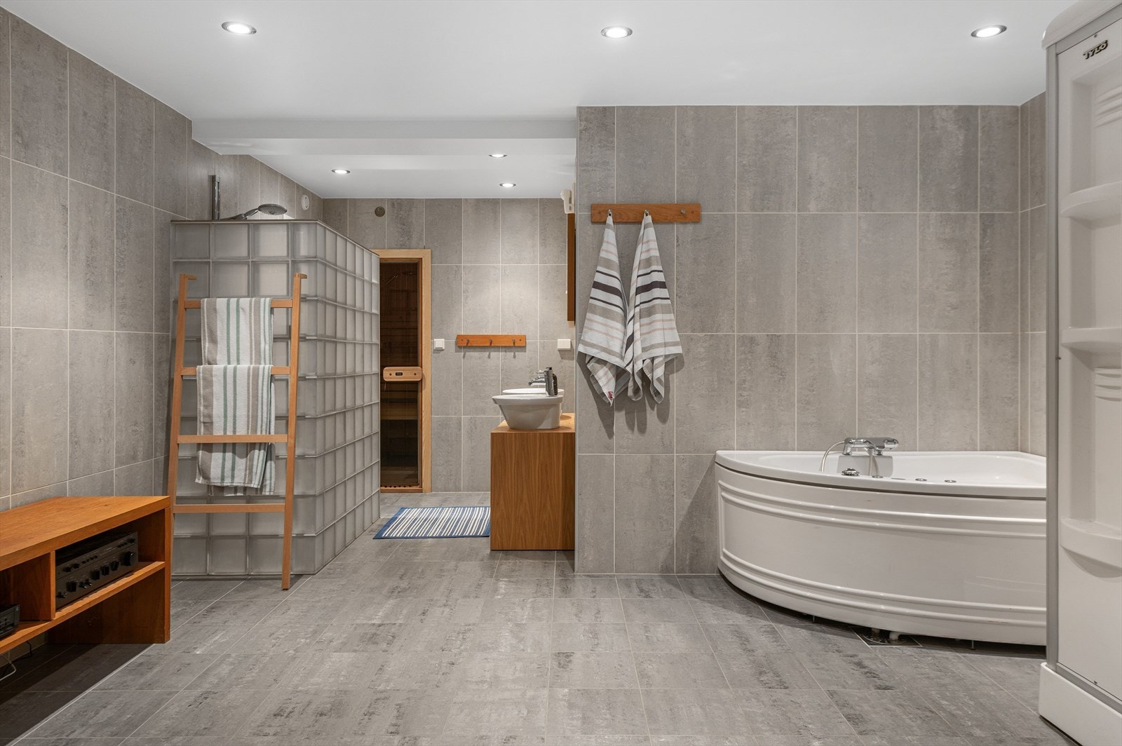 Spaavdeling med steamdusj, boblebad, servanter, dusj, WC og badstue. Galleribilde