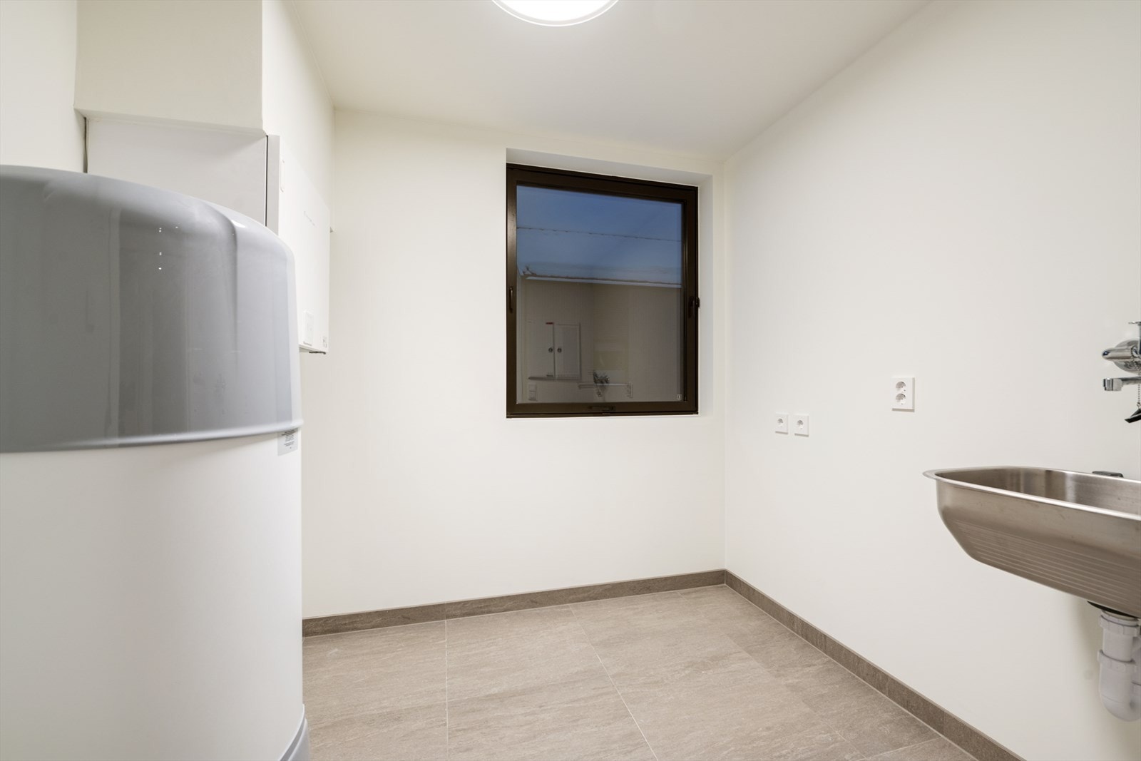 Vaskerom med skyllekar, varmtvannsbereder, opplegg for vaskemaskin, vannfordelerskap, sikringsskap og ventilasjonsagregat. Galleribilde