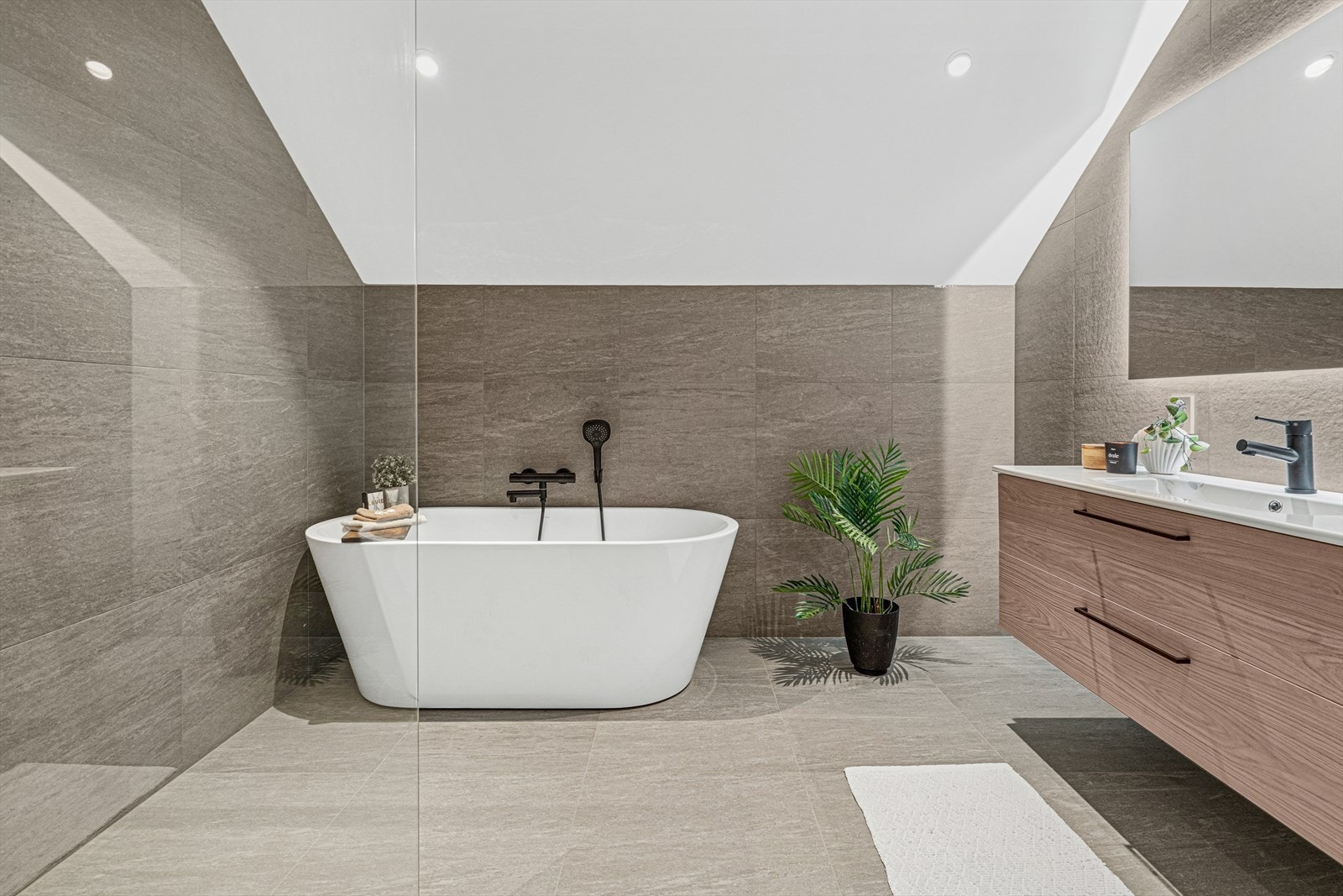 Baderom 3. etg. med innredning med nedfelt servant, veggmontert toalett, badekar og dusjvegger/hjørne. Galleribilde