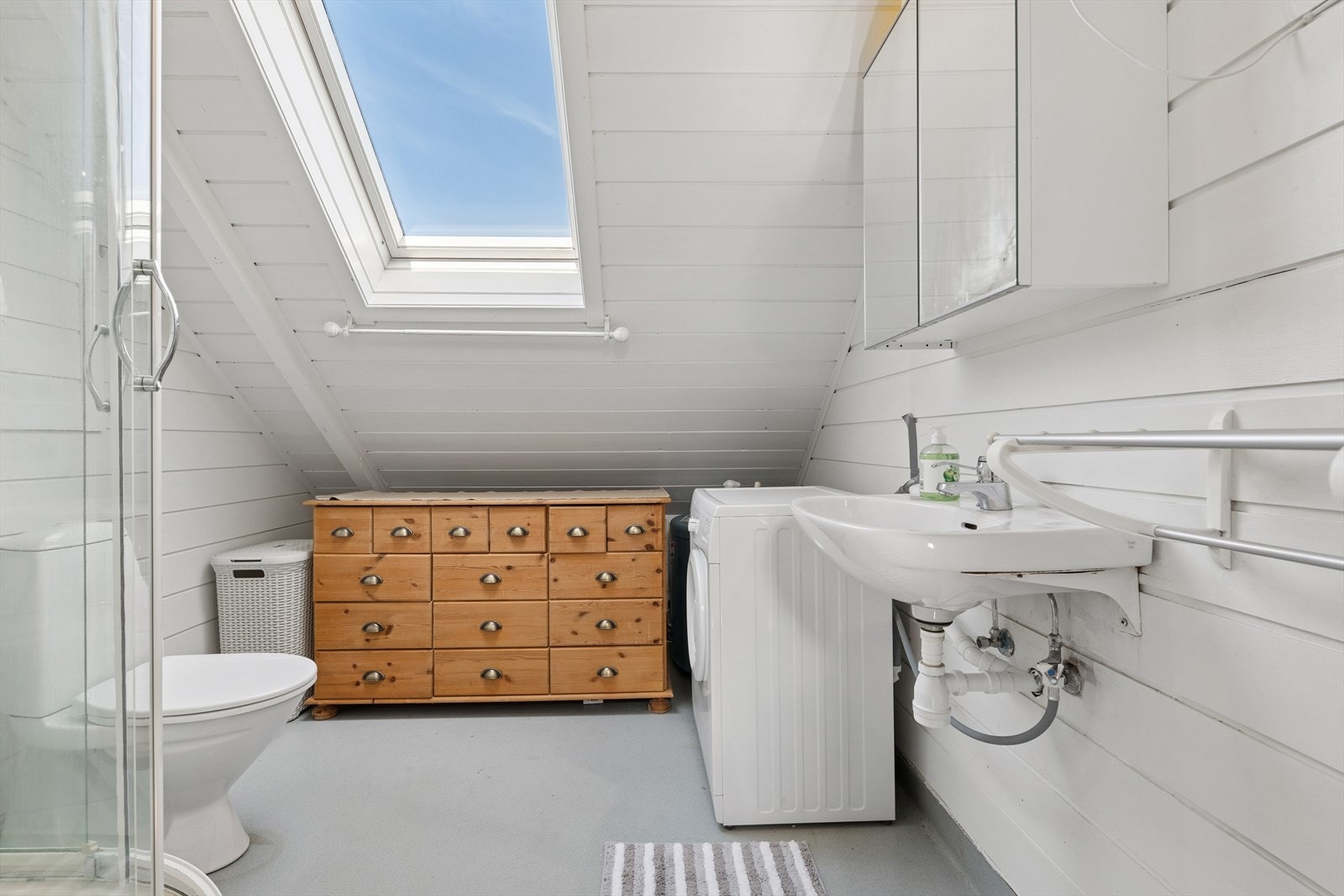 Badet på loftet har vinylbelegg på gulv og vegger/tak av trepanel. Galleribilde