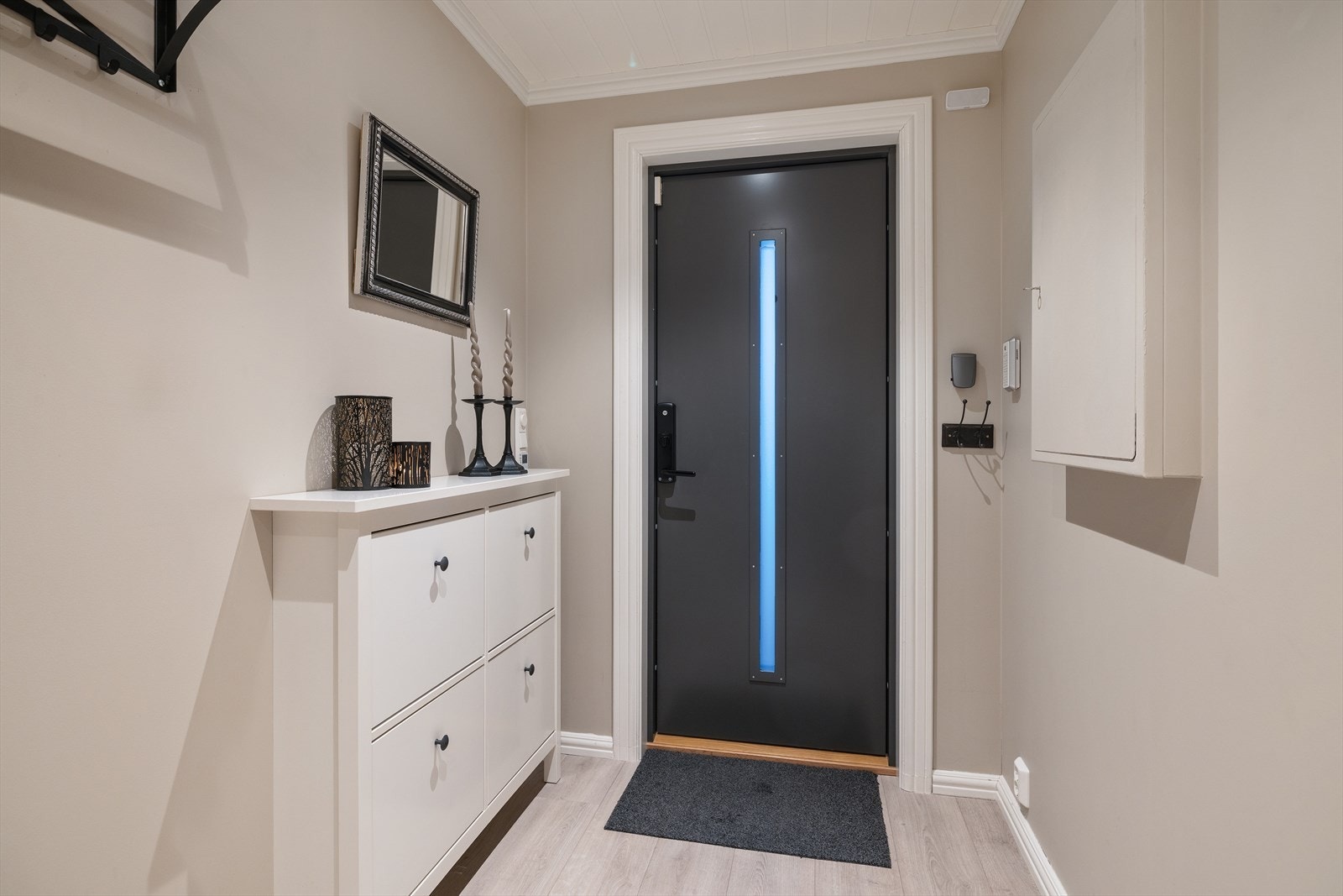 Velkommen inn i en lys og innbydende entré med en moderne ytterdør. Galleribilde