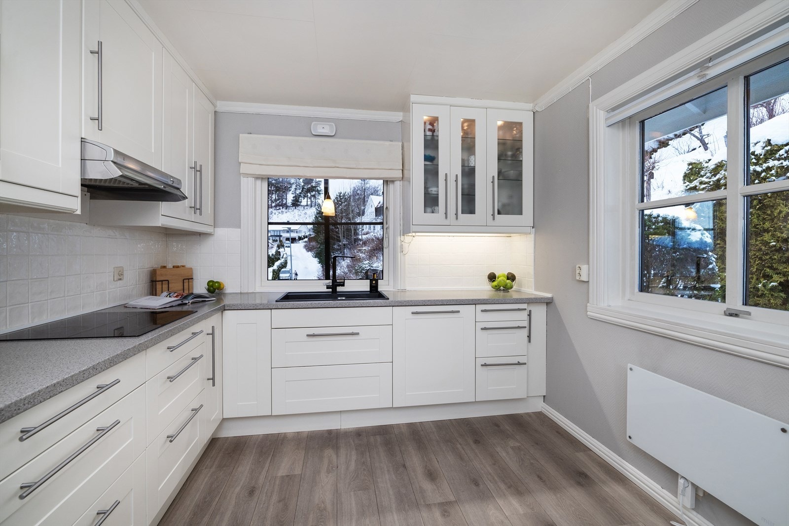 Vitrineskap med belysning og fliser over benken er fine detaljer. Galleribilde