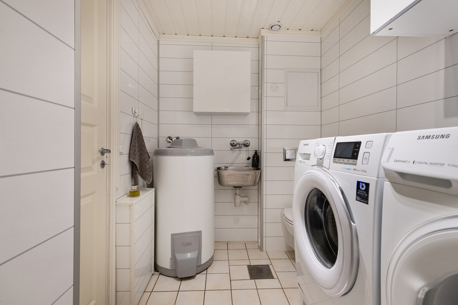 Praktisk vaskerom kombinert med bad, med opplegg for vaskemaskin og tørketrommel. Galleribilde