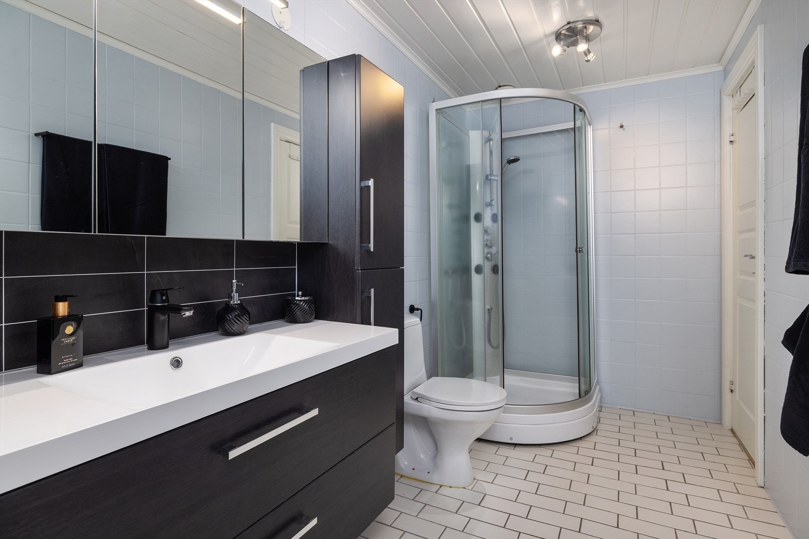 Baderomsinnredningen har heldekkende servant og speilskap med belysning. Galleribilde