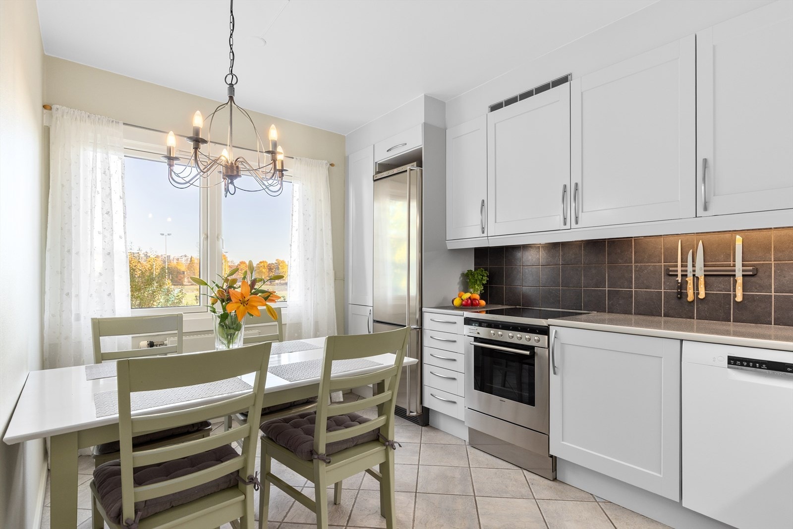 Lyst og pent kjøkken fra Norema med lyse, nymalte og lettprofilerte fronter. Galleribilde