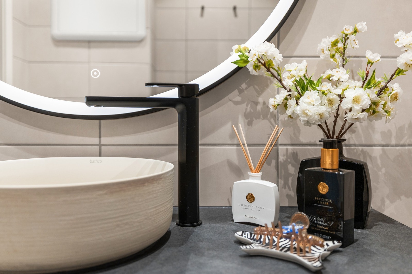 Rundt speil med kantbelysning over servant. Galleribilde