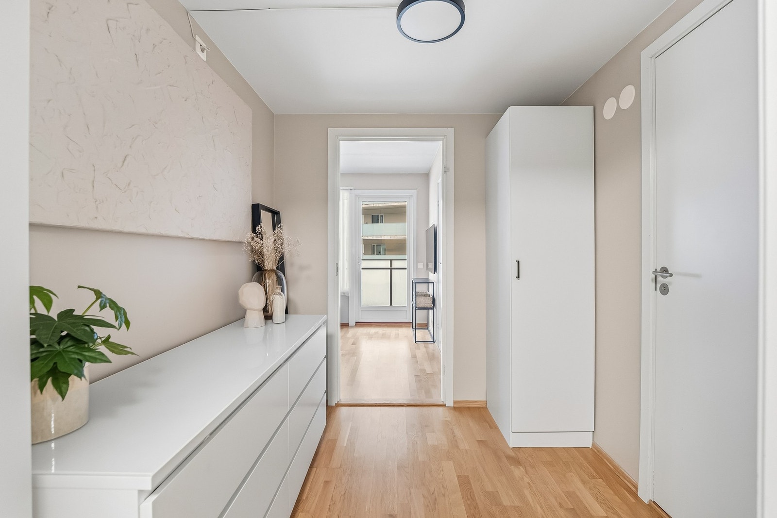 Tiltalende entre med parkett på gulv og lysmalte veggflater som gir et godt førsteinntrykk. Galleribilde