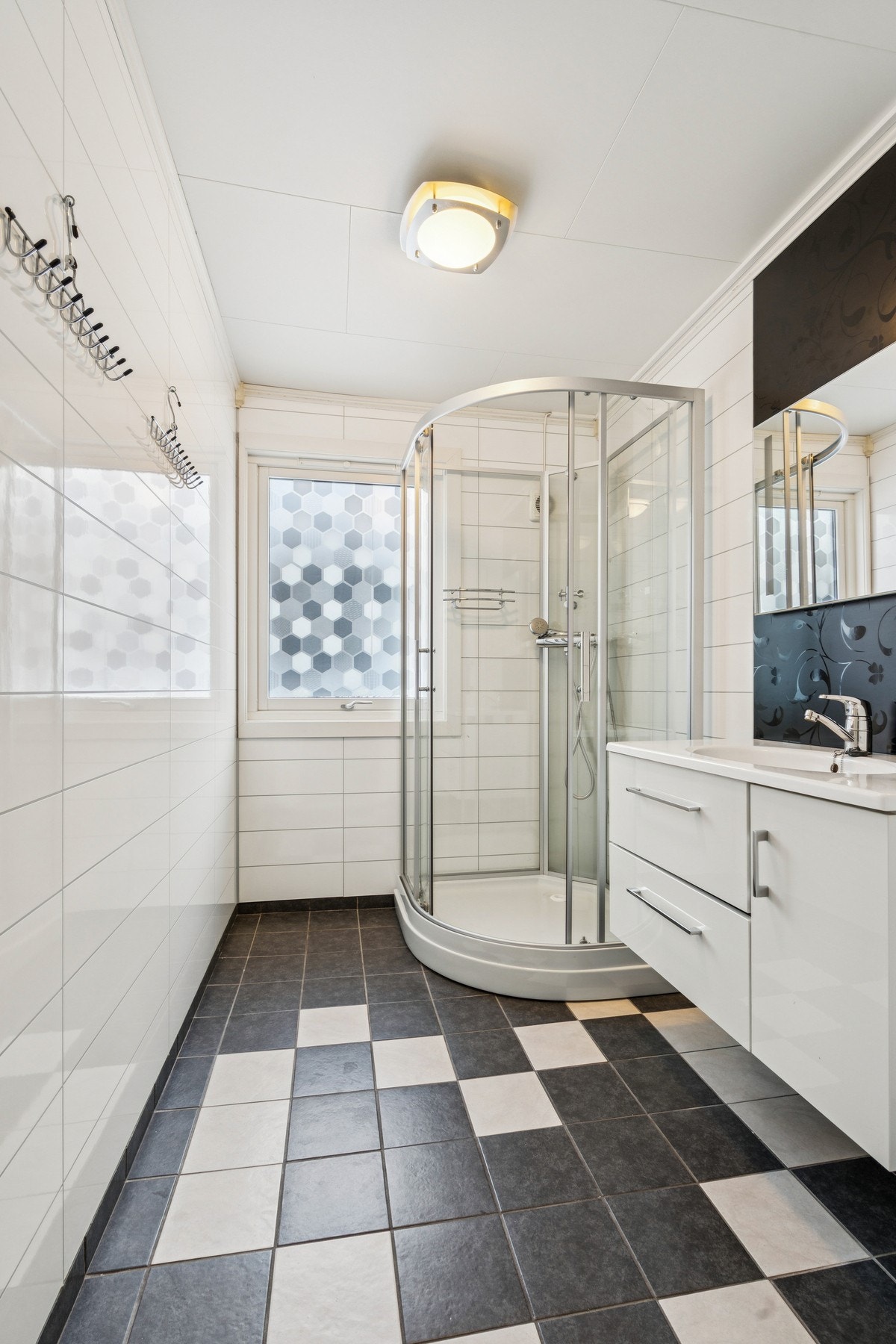 Baderommet har baderomsplater på vegg og flislagt gulv med sokkelfliser Galleribilde