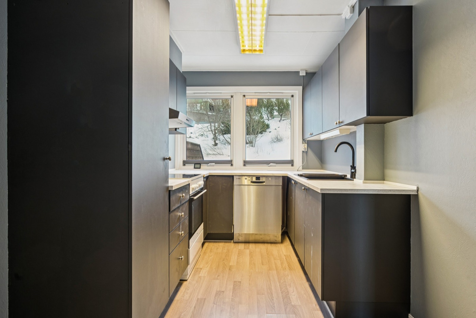 Veggene har tapetserte plater, himlingen er malt og gulvet har laminat Galleribilde