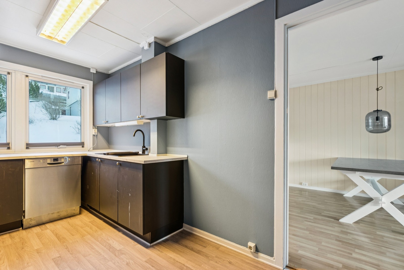 Kjøkkenet har en enkel innredning med laminatbenkeplate, oppvaskmaskin og ny kjøkkenvifte fra høsten 2025 Galleribilde