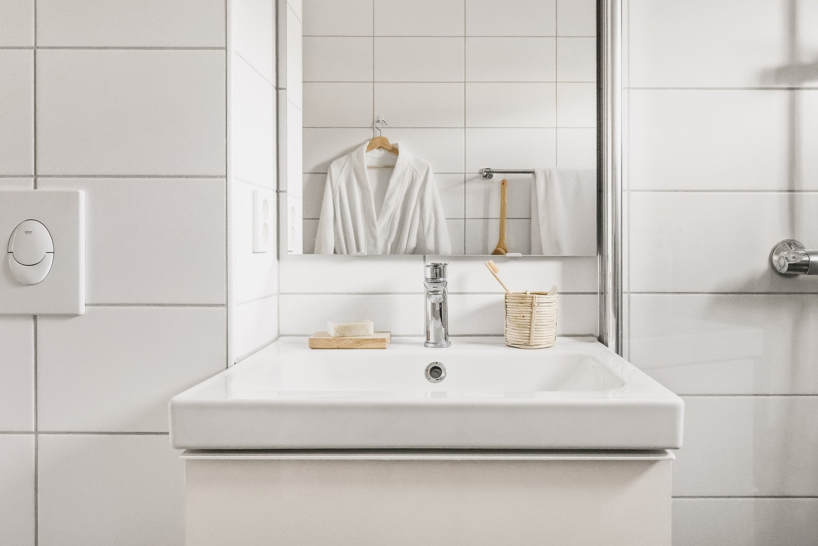 Badet er innredet med vegghengt toalett, servant med innredning, speilskap, dusjhjørne og opplegg for vaskemaskin. Galleribilde