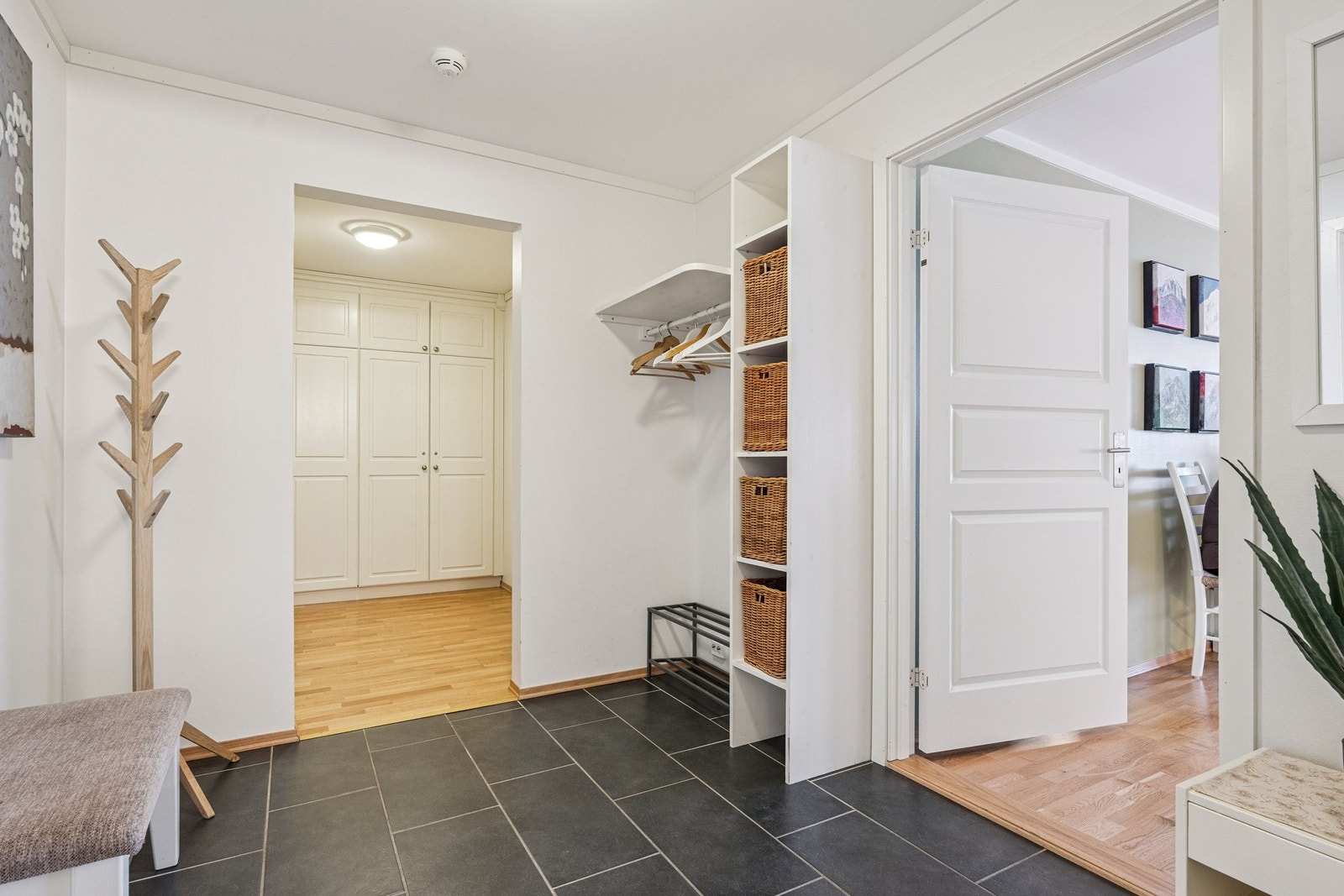 Romslig gang med gulvfliser og elektrisk gulvvarme. Garderobe. Alkove med div skap og lagringsplass. Galleribilde