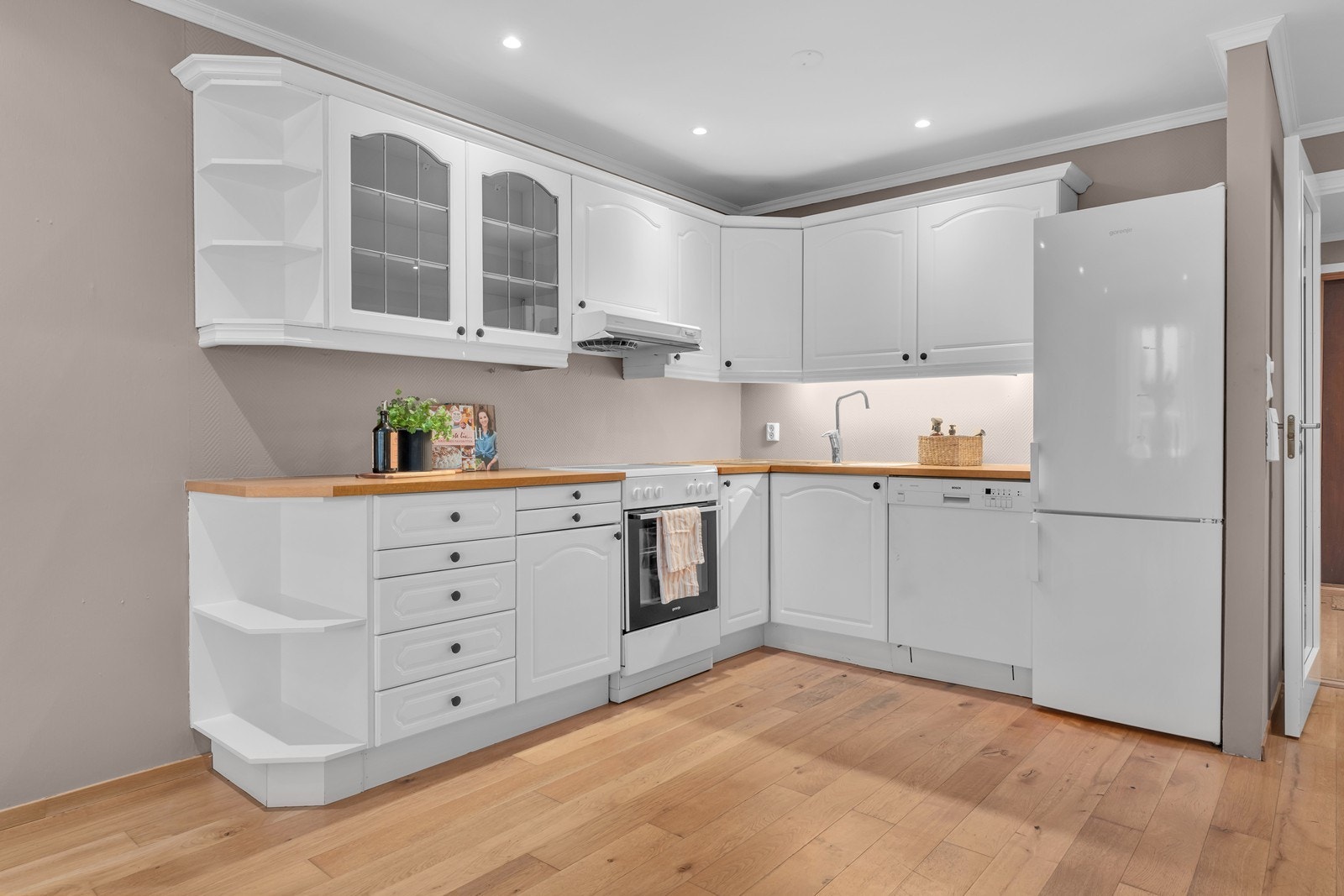 Sjarmerende kjøkken med bestående av frittstående og integrerte hvitevarer. Galleribilde