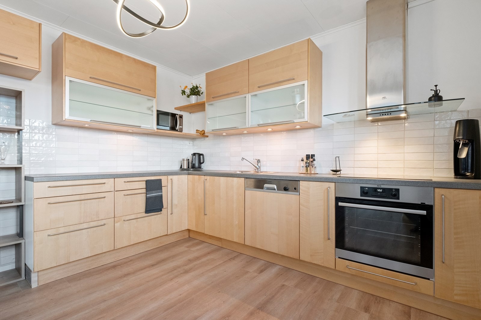 Pent og tidløst kjøkken med mye skap- og benkplass. Galleribilde